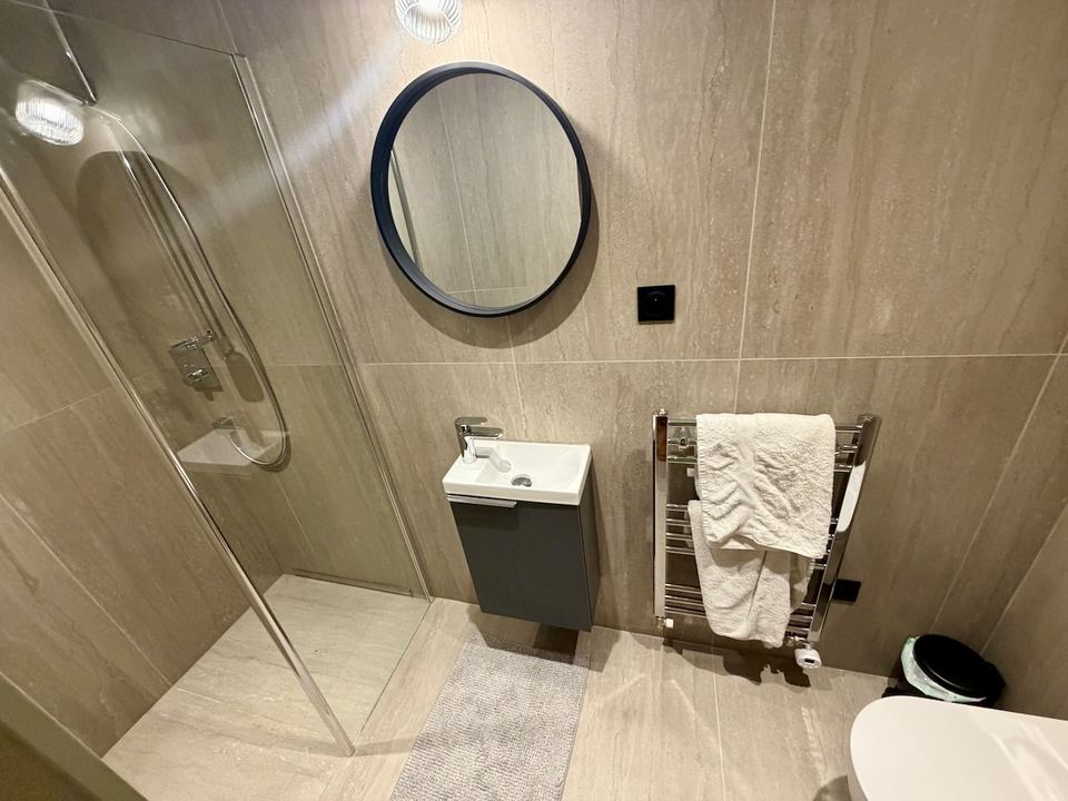 The master ensuite, new for the 2027 season — walk-in shower, basin and a heated towel rail.