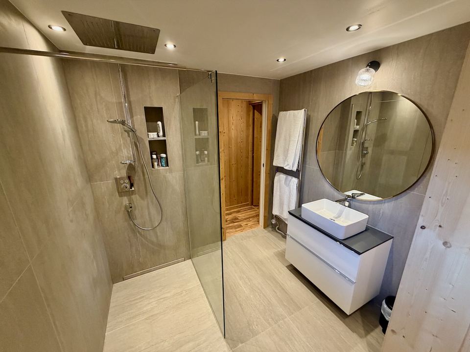 The family bathroom on the lower ground floor, refitted in the refurbishment — a large walk-in ceiling shower and underfloor heating.