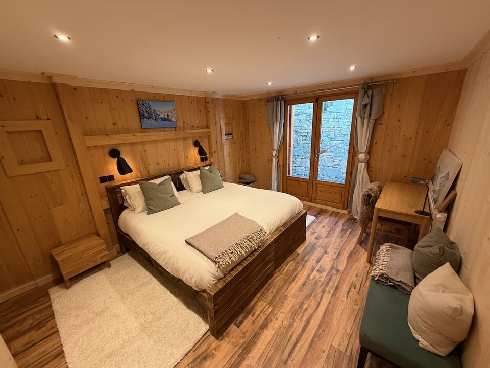 The master bedroom on the lower ground floor, with doors to the lower terrace.