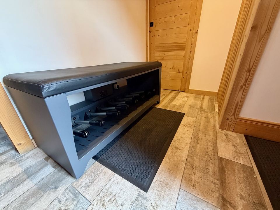 The boot and helmet warmer in the hall — twenty stalks inside the bench, so ten pairs of boots and/or helmets. It switches on by itself at 07:30 and again at 18:00.