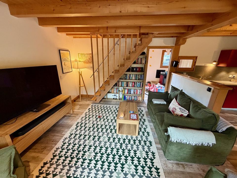 The living room, with the staircase up to the attic bedroom and a wall of books.