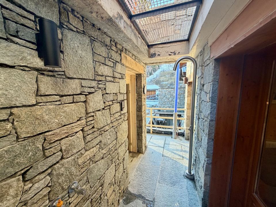 The outdoor hot shower, in the stone passage beside the lower terrace.