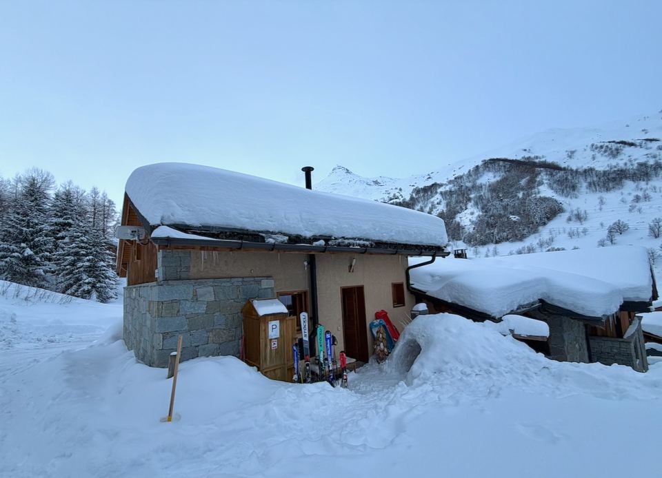Chalets in Le Bettaix under a deep roof of snow.